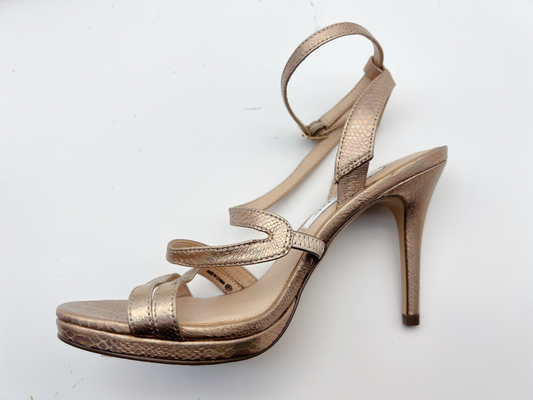 Le signore elastiche dell'involucro delicatamente rivestono di pelle l'argento scuro dei sandali con lo stiletto di 5cm