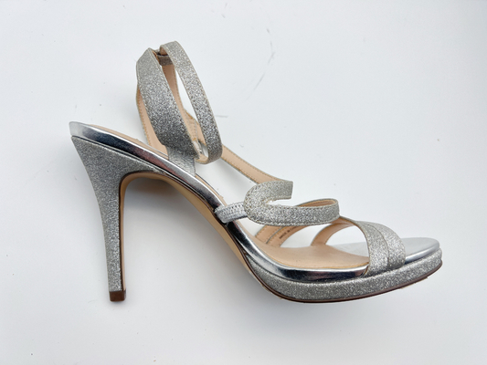 Le signore elastiche dell'involucro delicatamente rivestono di pelle l'argento scuro dei sandali con lo stiletto di 5cm