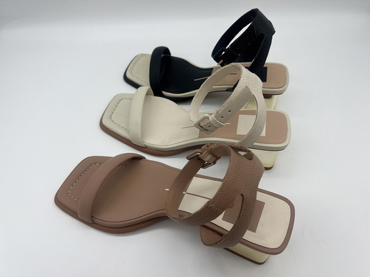 I sandali dell'una donna alla moda della cinghia, oro trasversale di cuoio della cinghia hanno riempito i sandali