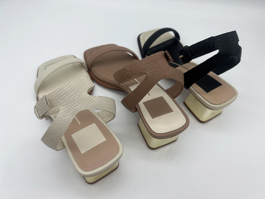 I sandali dell'una donna alla moda della cinghia, oro trasversale di cuoio della cinghia hanno riempito i sandali